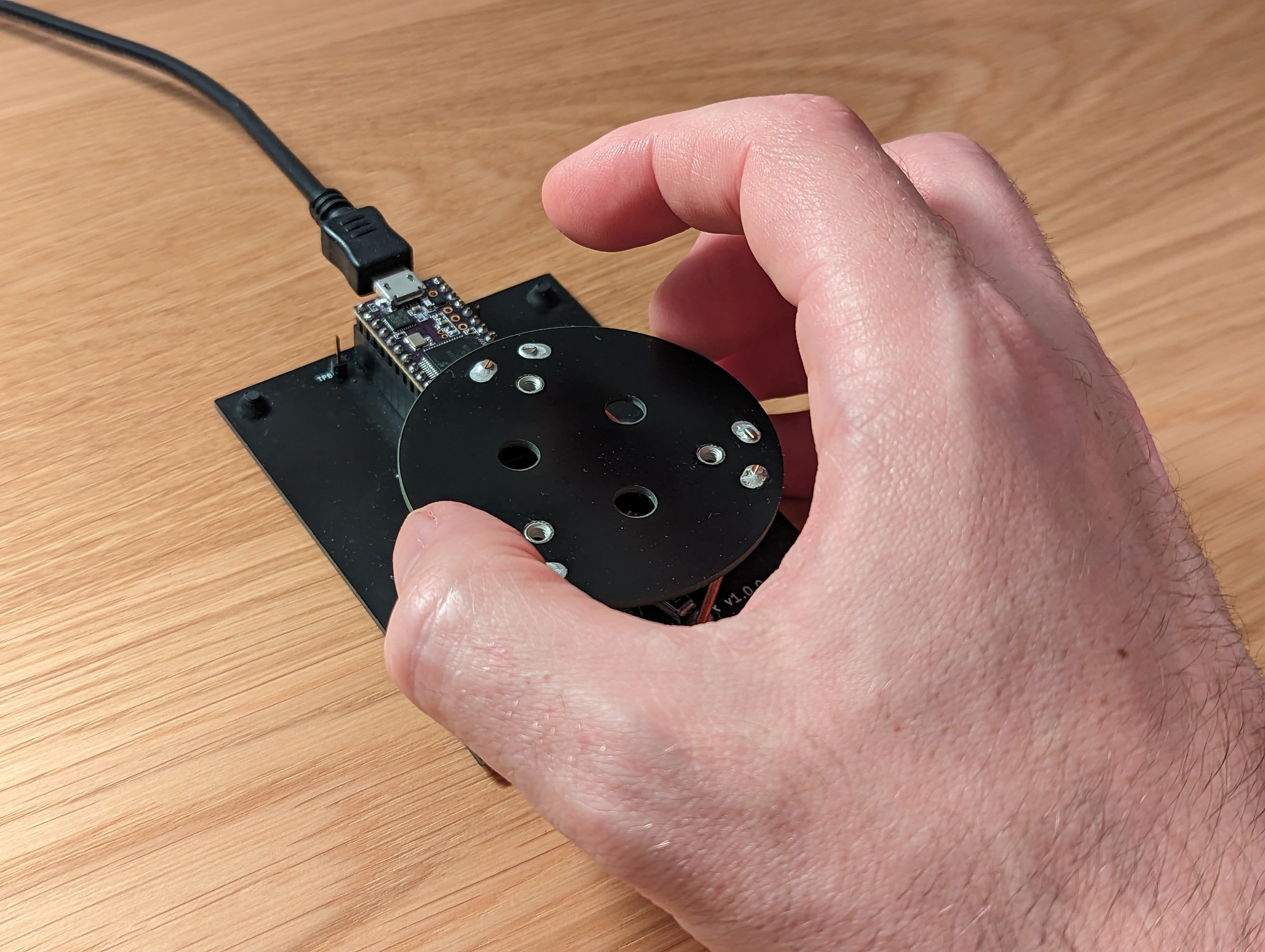The Haptick device previously imaged with a hand grabbing the top disc-like circuit board.