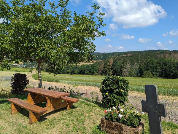 A well maintained picnic area on top of a hill with blue skies in the background.