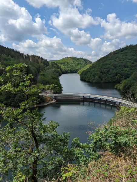 A view of a similar river with a curved dam bridge across it.
