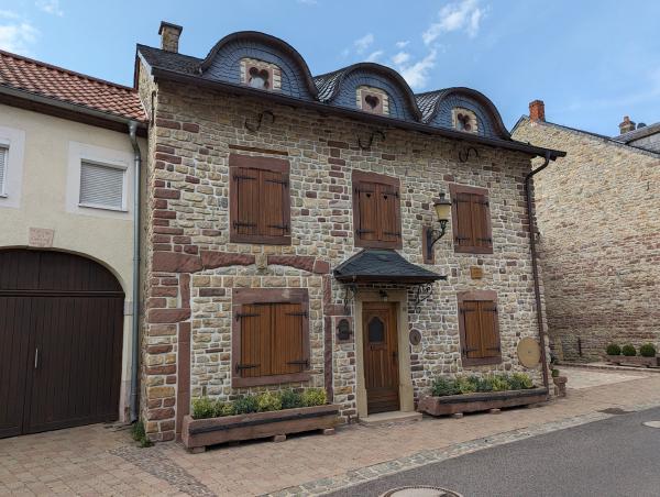 A pretty looking stone house with wooden shutters.