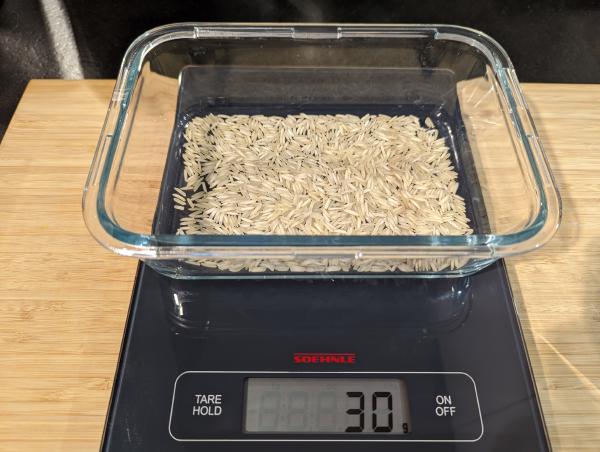The same baking dish with a layer of white rice in it. The scales now read 30 g.