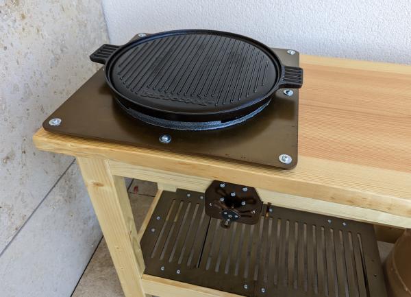 The benchtop and gas burner with a ridged BBQ plate on top.
